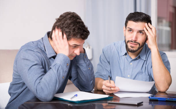 istock Two upset males with papers at table 1205538834