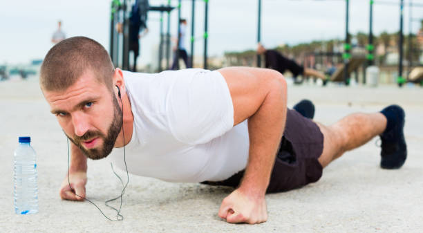 istock man performs push-ups on sportsground 1205538922
