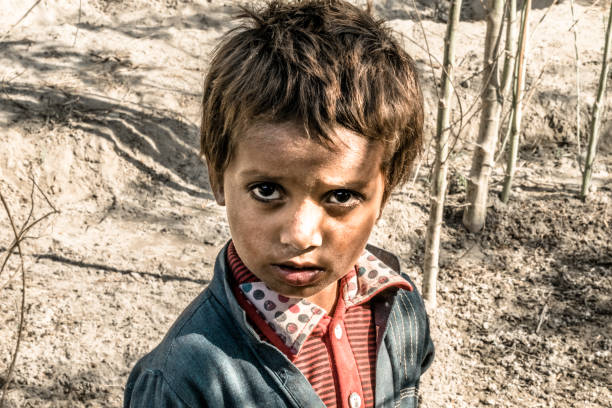 istock a young an innocent orphan boy is staring and feeling so lonely 1205539145