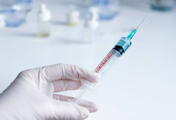 istock Scientist holding syringe with coronavirus test 1205539881