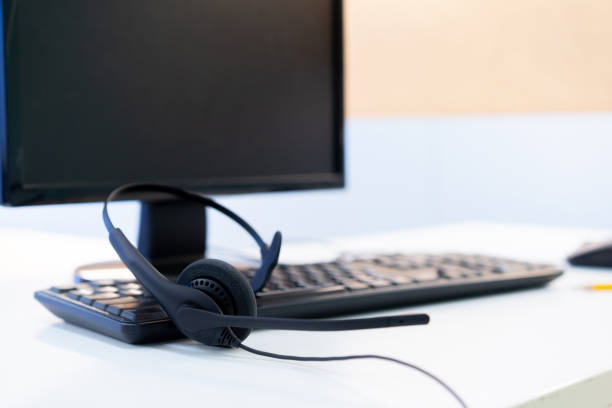 istock close up headset of call center and VOIP for communication technology on desktop pc computer table at the operational monitoring office room for telecommunication network  center concept 1205540243