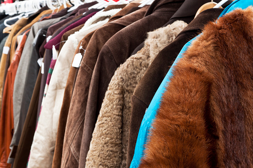 Close up secondhand winter coatsand jackets hanging the shop, full frame horizontal composition