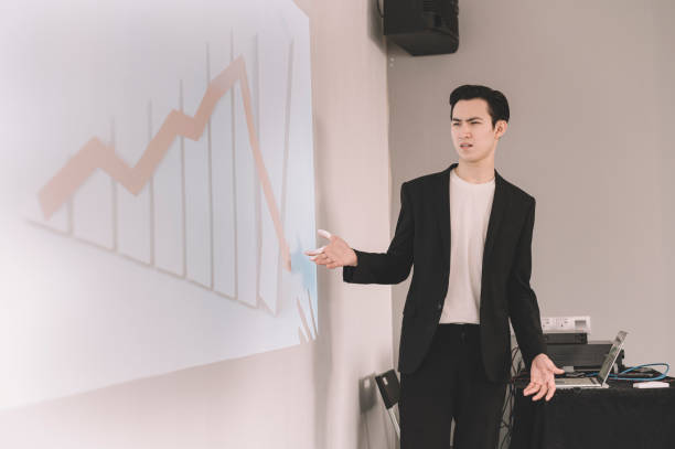 istock an asian chinese young white collar worker frustrated with his business negative forecast result during the meeting with projection on the wall 1205543671