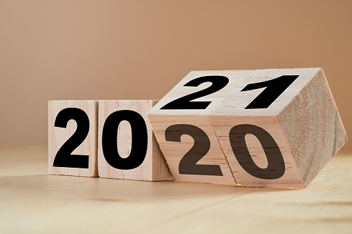 Flipping wooden cubes for new year change 2020 to 2021. New year change and starting concept.