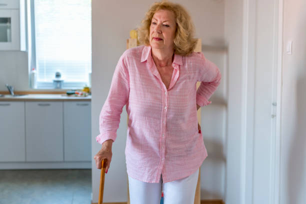 手術後のリハビリ中のシニア女性や自宅で歩く杖を持って歩く回復中の女性。リハビリテーションとヘルスケアの概念。 - human hand aging process senior adult cane ストックフォトと画像