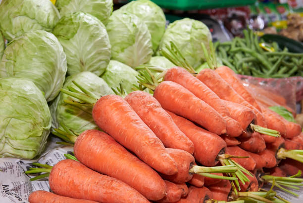 Close-up of different fresh ripe vegetables like carrots, beans and cabbage presented at a stall at a wet market in Iloilo, Philippines, Asia