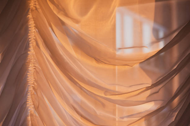 istock Elegant, thin transparent curtain on the window, by sunlight. Selective soft focus. 1205547719