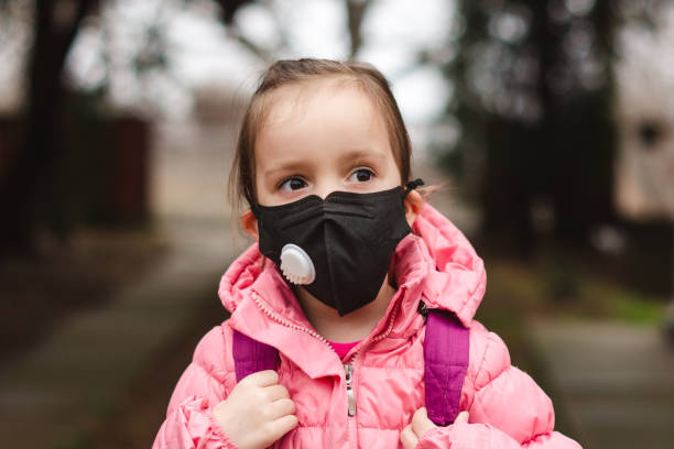 Little girl wearing pollution mask. Portrait of a little girl wearing pollution mask going to kindergarten. weather protection clothing stock pictures, royalty-free photos & images