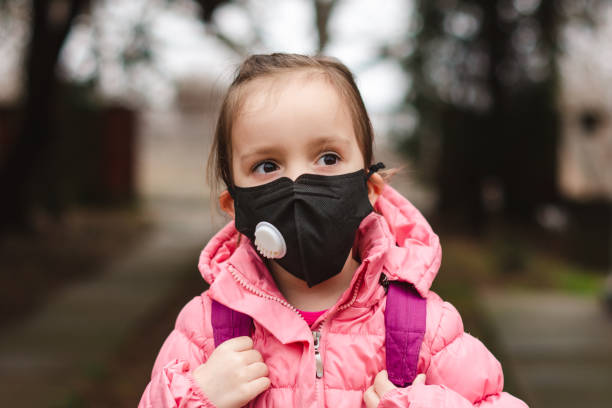 маленькая девочка в маске загрязнения. - little girls only фотографии стоковые фото и изображения