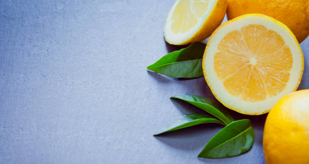 istock Fresh yellow citrus fruit -  lemon on the grey background -  copy space. 1205547994