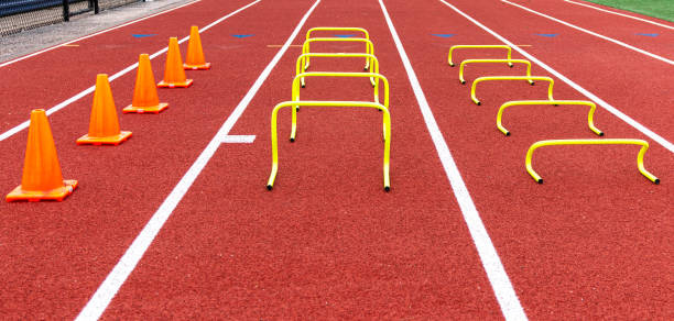 istock Orange cones and yellow mini hurdles set up on a red track 1205548345