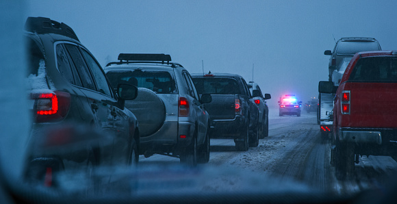Disparo desde el frente de un vehículo mientras era detenido por un accidente y trabajadores de emergencia en una interestatal durante una tormenta de nieve en el anochecer photo