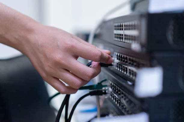 da vicino sulla mano della donna ingegneristica cercando di collegare lan per cambiare il livello 2 per la condivisione di file e reti tra hq e filiale per l'industria della tecnologia delle telecomunicazioni e il concetto di business - it support network server technology security system foto e immagini stock