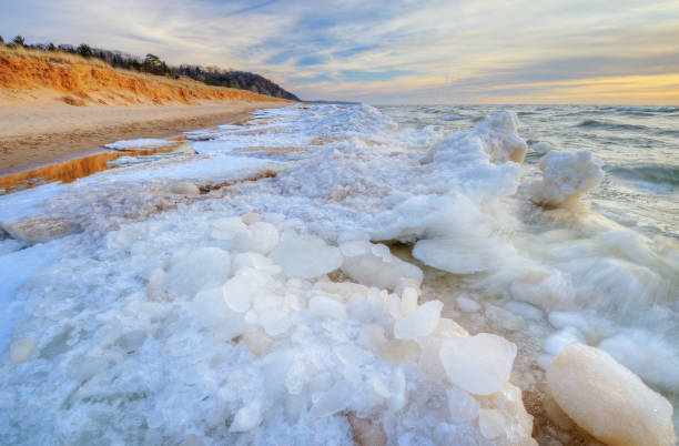 Landscape of the iced winter shoreline of Lake Michigan at sunset, Saugatuck Dunes State Park, Michigan, USA