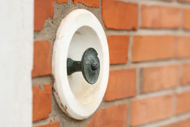 Photo of an old doorbell on a brick wall in Venice