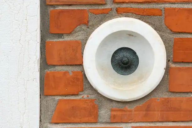 Photo of an old doorbell on a brick wall in Venice