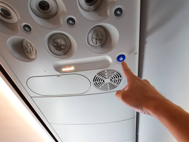 Asian men hand pressing the button in the passenger air plane to call flight attendant, cabin crew for a service. With airplane ventilation and interior as a background. Asian men hand pressing the button in the passenger air plane to call flight attendant, cabin crew for a service. With airplane ventilation and interior as a background. call button stock pictures, royalty-free photos & images