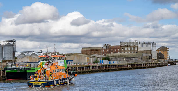 great yarmouth rnli offshore lifeboat motoring down the river yare during the annual maritime festival - great yarmouth england norfolk river imagens e fotografias de stock