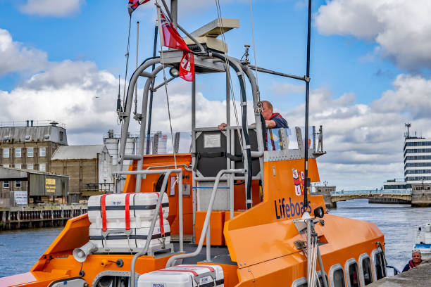 close up of orange rnli inshore lifeboat moored up in yarmouth docks and on display during the annual maritime festival - great yarmouth england norfolk river imagens e fotografias de stock