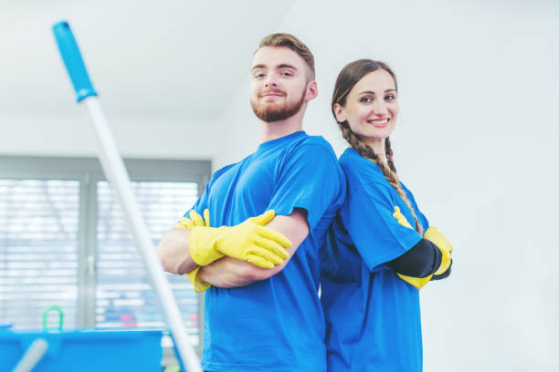 Cleaners being proud of their service standing arms folded stock photo