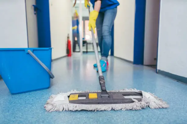 Photo of Close-up of cleaners moping the floor