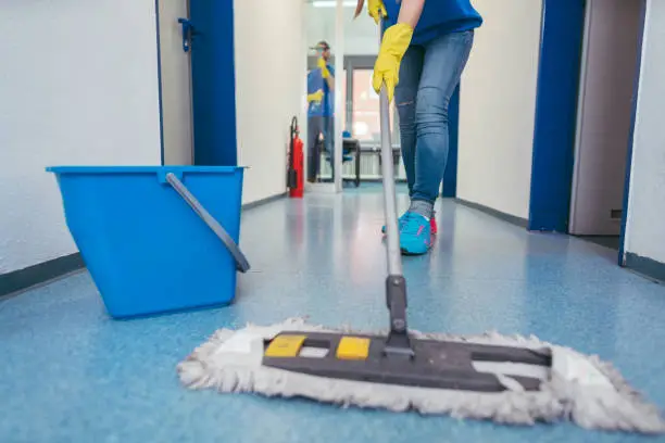 Photo of Close-up of cleaners moping the floor