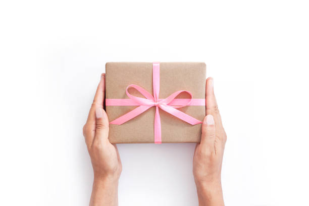 istock Female hands holding present box or gift box package in craft paper 1205557962