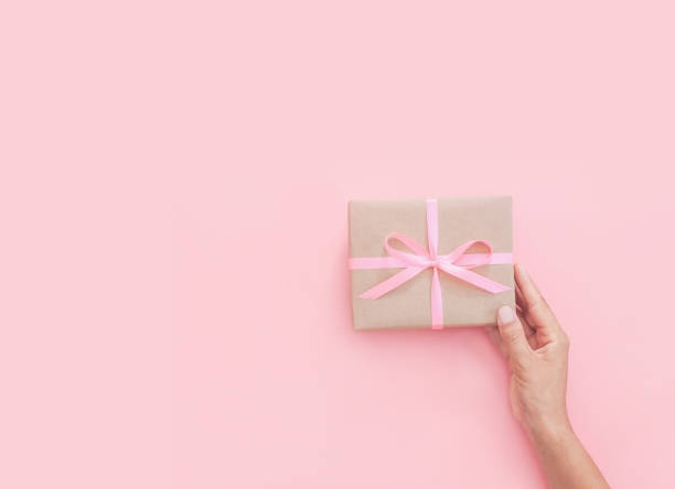 istock Female hands holding present box or gift box package in craft paper 1205557986