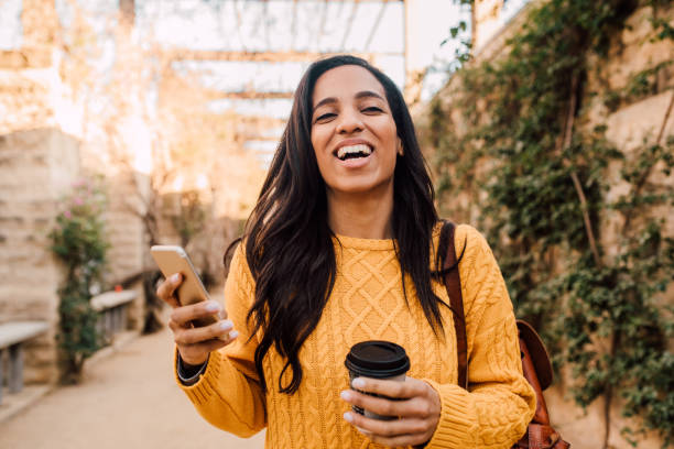 istock Girl in a walk using phone and drinking coffee 1205558808