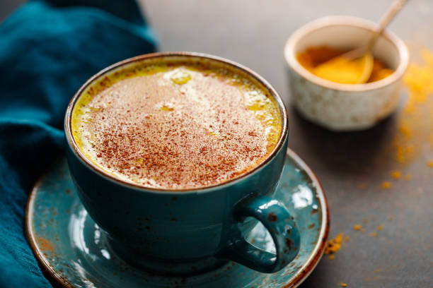 istock Closeup view of turmeric latte cup on a textured dark background. 1205558905