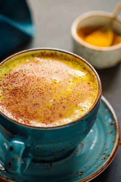 istock Closeup view of turmeric latte cup on a textured dark background. 1205558909