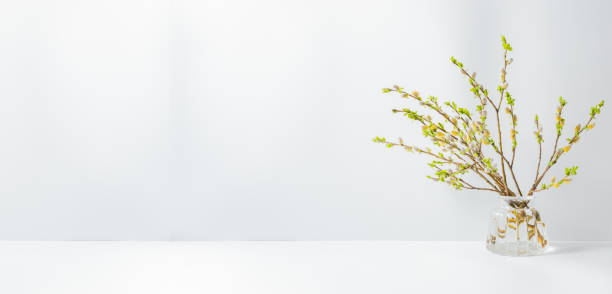 istock Home interior with easter decor. Willow branches in a glass vase on a light background 1205559466