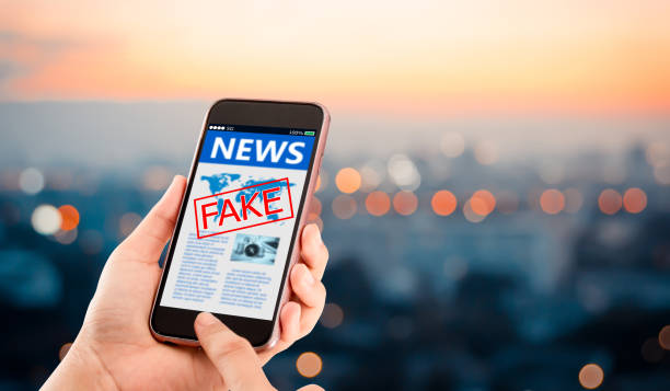 Fake news,Hoax concept. Hands holding mobile phone on blurred night city as background fake news stock pictures, royalty-free photos & images