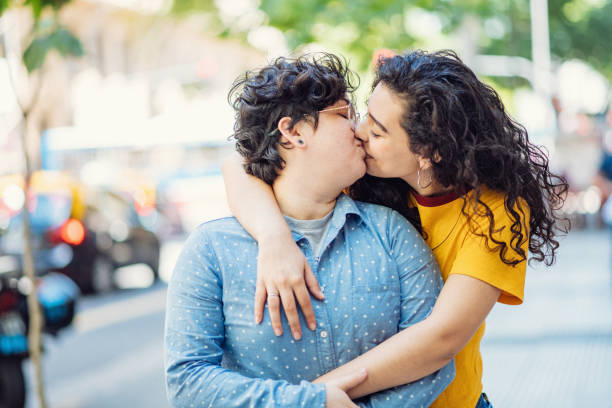 istock Diverse lesbian couple kissing outdoors in summer 1205560854