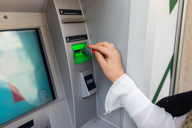 istock Midle age woman is withdrawing money from ATM machine 1205561272