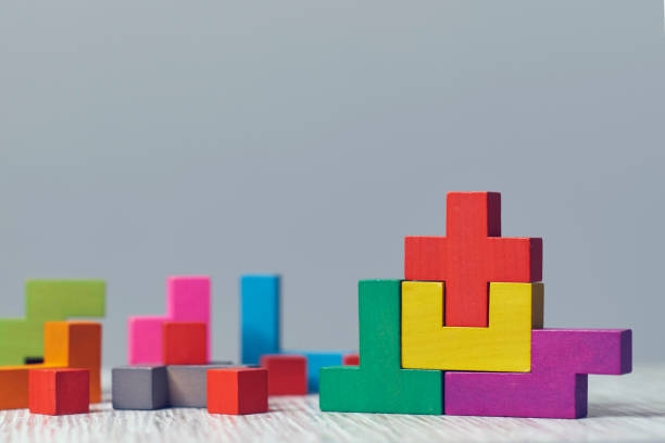 istock wooden block puzzle. wood cube stacking. Concept of complex and smart logical thinking. Slightly defocused and close up shot. on a red background 1205563828