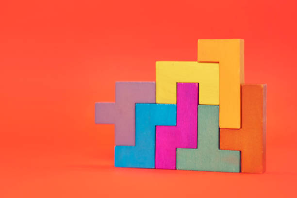 istock wooden block puzzle. wood cube stacking. Concept of complex and smart logical thinking. Slightly defocused and close up shot. on a red background 1205564037