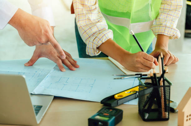 istock construction worker team meeting and planning about building plan with blueprint, construction tools on conference table at construction site, contractor, business, industry and construction concept 1205565792