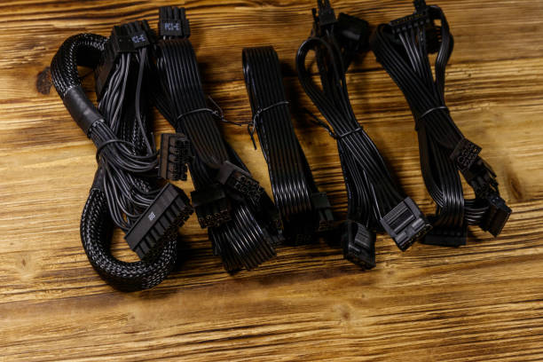 istock Set of cables for computer PSU on a wooden desk 1205565977