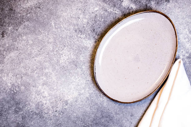 istock Culinary background with empty plate and napkin on a grey slate, stone or concrete table.Top view with copy space. 1205566753