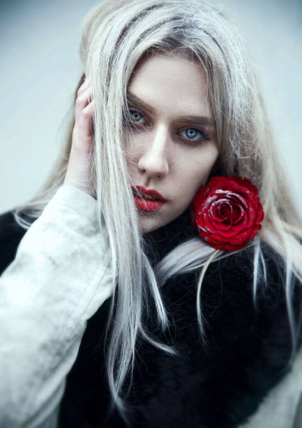 istock Young woman with rose flower 1205568580