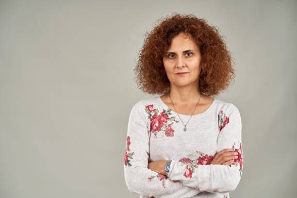 istock Curly haired redhead lady on gray 1205568583