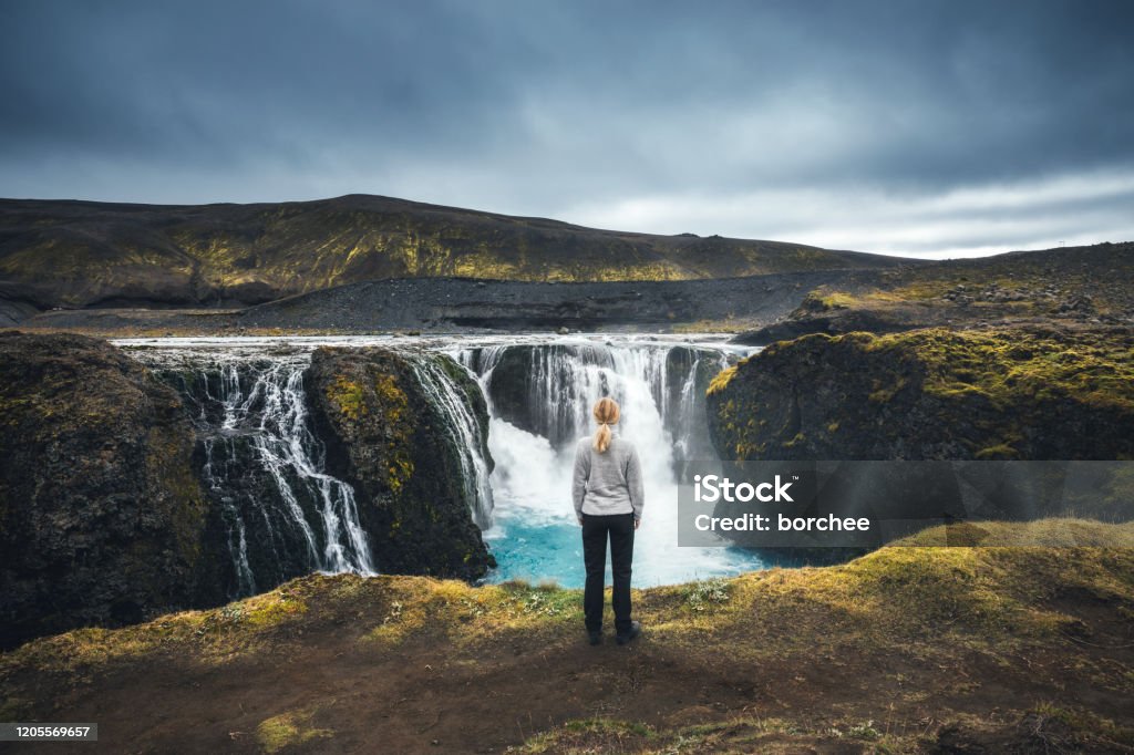 Sigoldufoss In Iceland Woman standing in front of beautiful Sigoldufoss waterfalls in Iceland's highlands. Waterfall Stock Photo