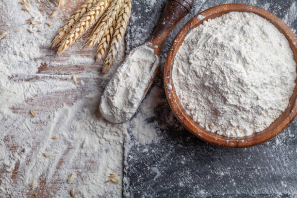 istock Wheat flour with scoop and wheat ears on kitchen board top view. Ingredient for baking. 1205569783