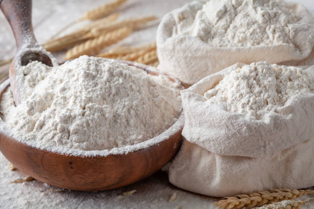 istock Wheat flour in wooden bowl and burlap bag on kitchen table. Ingredient for baking. 1205569848