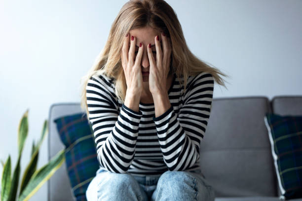 istock Depressed young woman thinking about her problems while sitting on the sofa at home. 1205572395