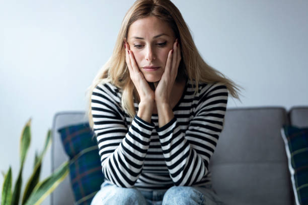 istock Depressed young woman thinking about her problems while sitting on the sofa at home. 1205572429