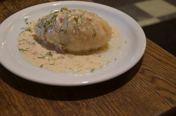 Cepelinai (Zeppelins) Lithuania’s national dish, a large dumplings made of a mixture of raw and cooked potato dough that is filled with pork and doused in a ladle of a sour cream and bacon sauce.