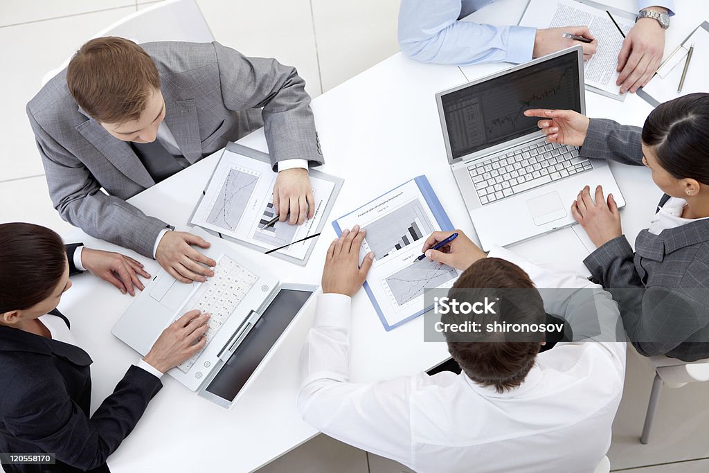 Teamwork Above view of business team sitting around table and working Adult Stock Photo