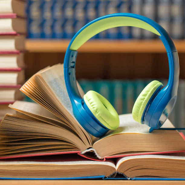 istock Audio book concept - headphones with books at the library 1205584569